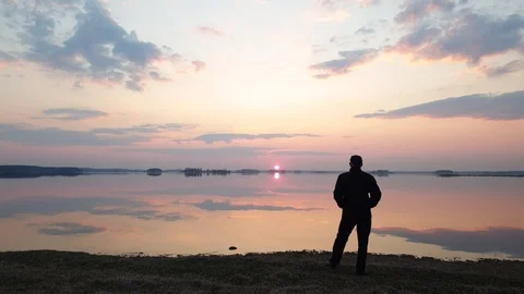 Man on the background of the sunset on the lake. Stock Footage 107185888