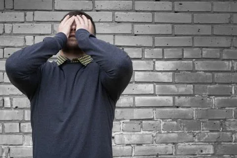 Man on the background of a wall of white bricks. Stock Photos