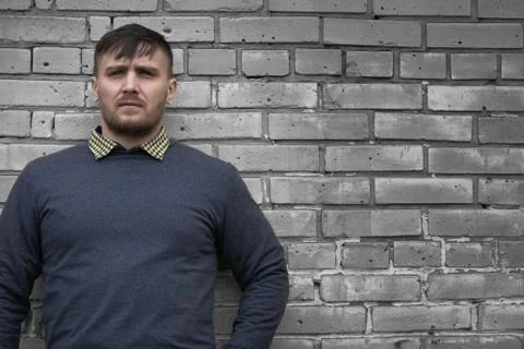 Man on the background of a wall of white bricks. Stock Photos