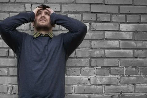 Man on the background of a wall of white bricks. Stock Photos