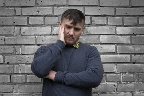 Man on the background of a wall of white bricks. Stock Photos