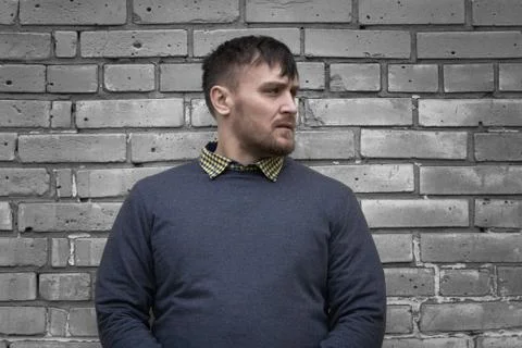 Man on the background of a wall of white bricks. Stock Photos