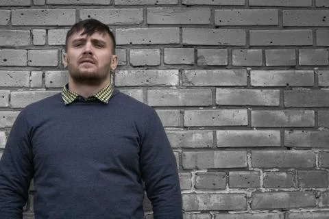 Man on the background of a wall of white bricks. Stock Photos