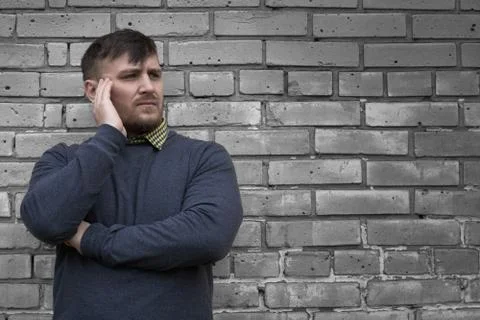 Man on the background of a wall of white bricks. Stock Photos