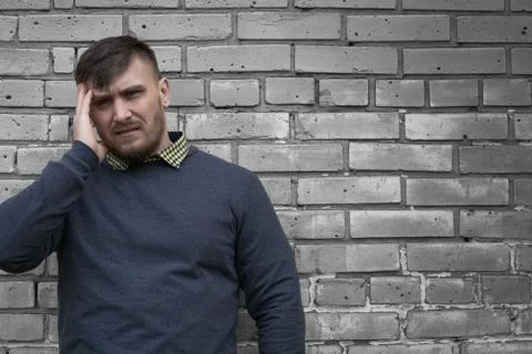 Man on the background of a wall of white bricks. Stock Photos