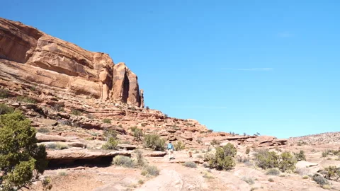Man With Backpack and Dog Walking Uphill in Desert Landscape of Utah USA Stock Footage 345379295