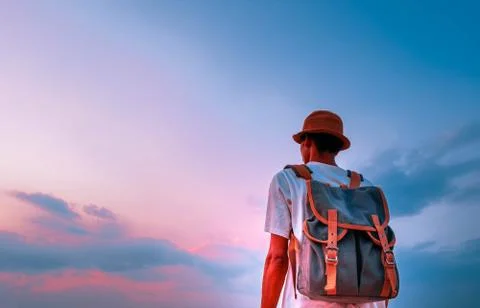 Man with backpack and looking beautiful sky in sunset. concept for adventure Stock Photos