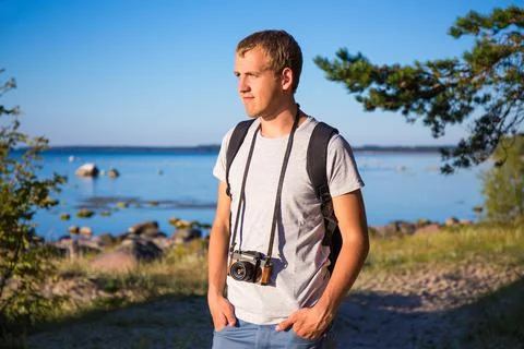 Man with backpack and retro camera on the beach Stock-Fotos