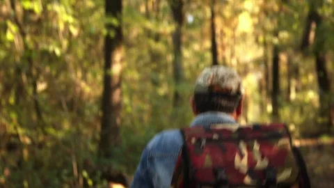 A Man with a Backpack on an Autumn Forest Path. Hiker Exploring the Woods. .. Stock Footage 315031335