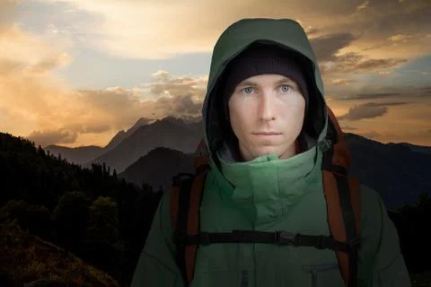 Man with backpack on the background of mountain sunset. Hiking. Stock Photos