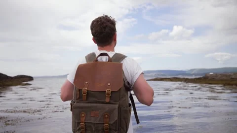 Man with a backpack on the beach. Portrait of a guy with a backpack in glasses Stock Footage 250180282