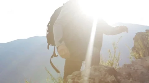 A man with a backpack is climbing a rocky mountain Stock Footage 73349717