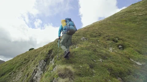A man with a backpack climbs the mountain, conquers the top of the mountain Stock Footage 238449091