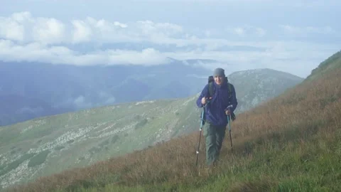A man with a backpack climbs the mountain, conquers the top of the mountain Stock Footage 238754239