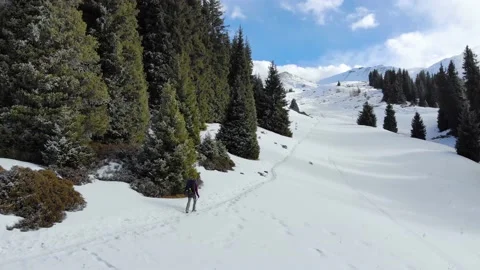 A man with a backpack climbs the mountains in winter Stock Footage 168905198