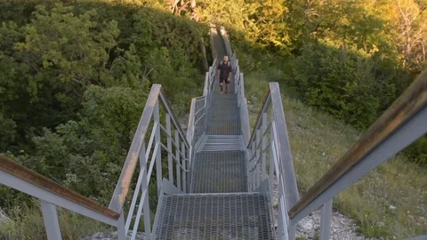 Man with backpack climbs the stairs in the mountains Video stock 72597806