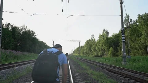 Man with backpack could not catch up with train and sits on rails Stock Footage 158682872