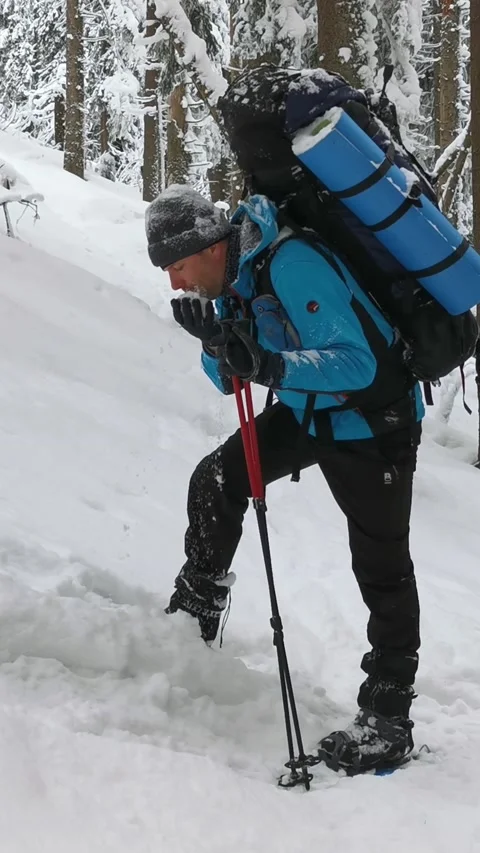 Man With A Backpack Eats Snow On A Hiking Winter Hike. Stock Footage 220412219