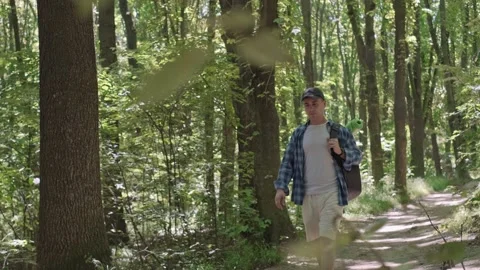 A man with a backpack exercises in the forest, outdoor fitness featuring active Stock Footage 280186380