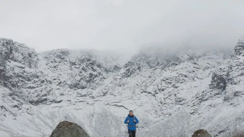 A man with a backpack goes on the background of large mountains. Video stock 97809882