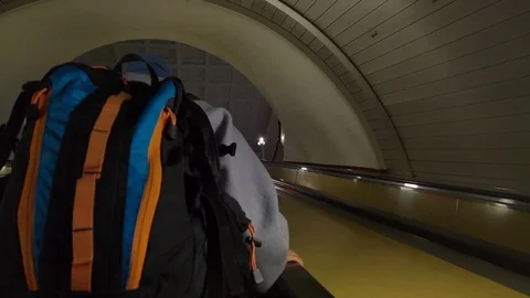 A man with a backpack goes up the escalator at the station Belorusskaya 스톡 동영상 100452195