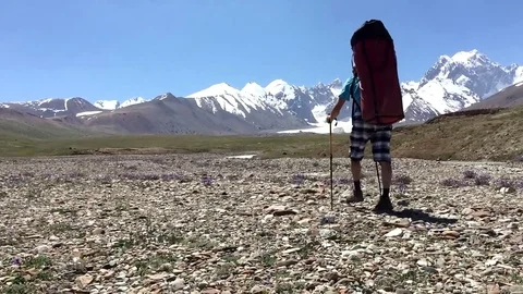 A man with a backpack goes to the mountain. Trekking in the mountains Stockbeeldmateriaal 69772370