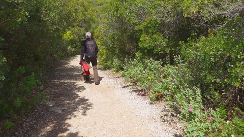 A Man with a Backpack goes Uphill Stock Footage 90093480