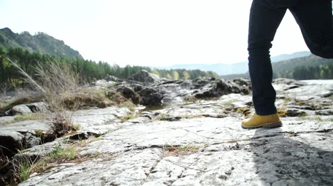 Man with backpack in hand walking down a mountain road Видео 63382344