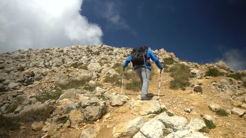 Man with backpack hiking and climbing the rocks, reaching the top of Oshten peak Stock Footage 99426514