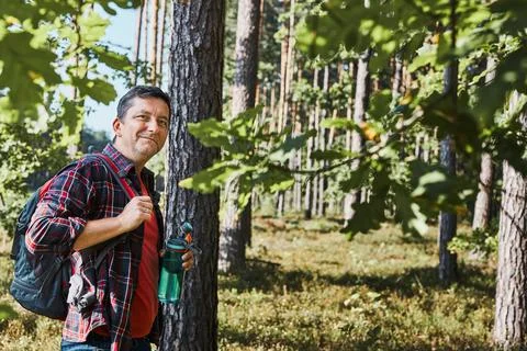Man with backpack hiking in forest, actively spending summer vacation close.. Stock Photos