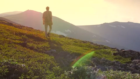 A man with a backpack is Hiking in the mountains.  Stock Footage 135370906