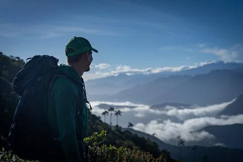 Man with backpack looking at mountain view. Travel and adventure concept. Stock Photos