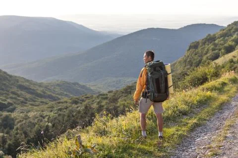 Man with backpack looking at the valley Foto stock