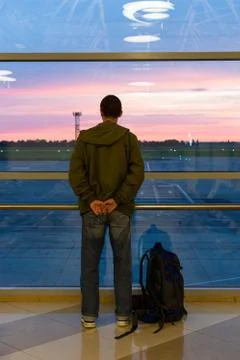 Man with a backpack looks at the planes Stock Photos