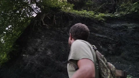 Man with backpack moves past scree with protruding tree roots. Selective focus Stock Footage 208882344