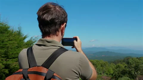 Man with backpack photographing scenic landscape on sunny day, Travel Видео 280177386