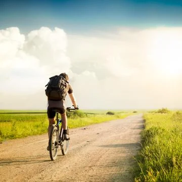 Man with Backpack Riding a Bicycle Stock Photos