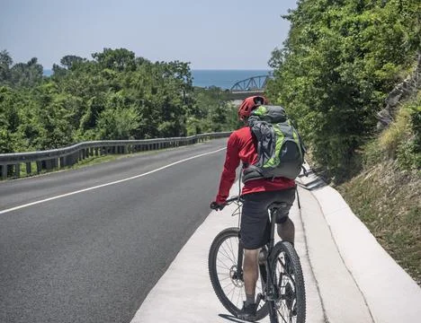 Man with backpack riding bicycle 스톡 사진