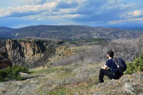 A man with a backpack sitting and staring at Momini scali Stock Photos