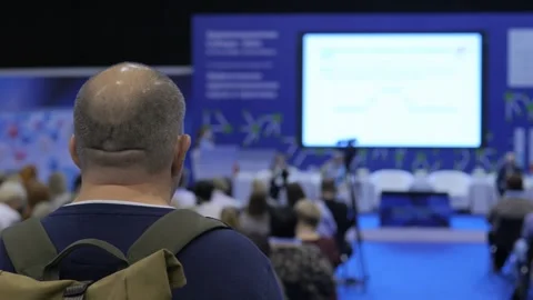 Man with a backpack is sitting in a room full of people Stock Footage 300445197