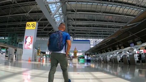 A man with a backpack slowly walks through the airport Stock Footage 174943010