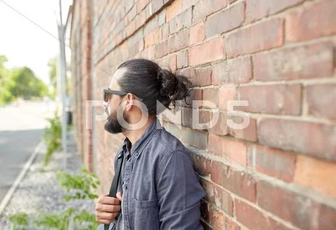Man with backpack standing at city street wall Stock Photos