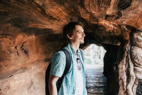 Man With Backpack Standing in Massive Hollow Tree Tunnel Stock Photos