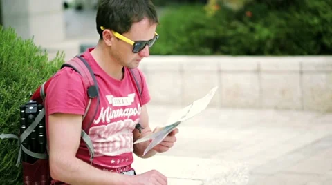 Man with backpack on the street watching to the map Stock Footage 57109817