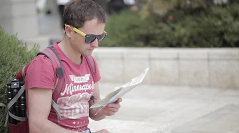 Man with backpack on the street watching to the map Stock Footage 57110398