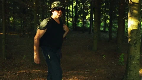 A man with a backpack strolls through the forest. 库存影片 95723430
