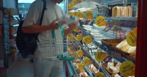 Man backpack takes package meat shelf, adds it basket, his shopping process. His Stock Footage 275082789