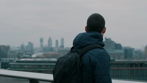 Man with backpack taking in the distant city view Stock Footage 130972170