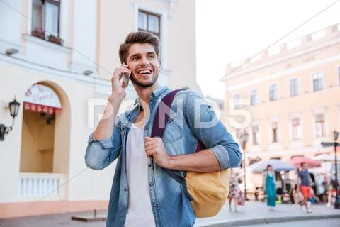 Man with backpack talking on mobile phone in the city Stock Photos