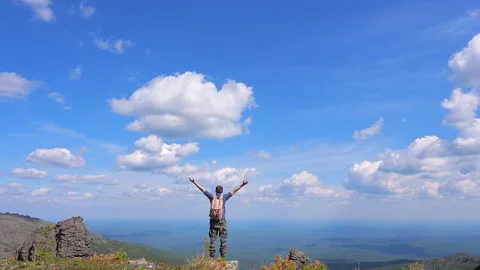 A man with a backpack is traveling through the mountainous area. Stock Footage 135189286